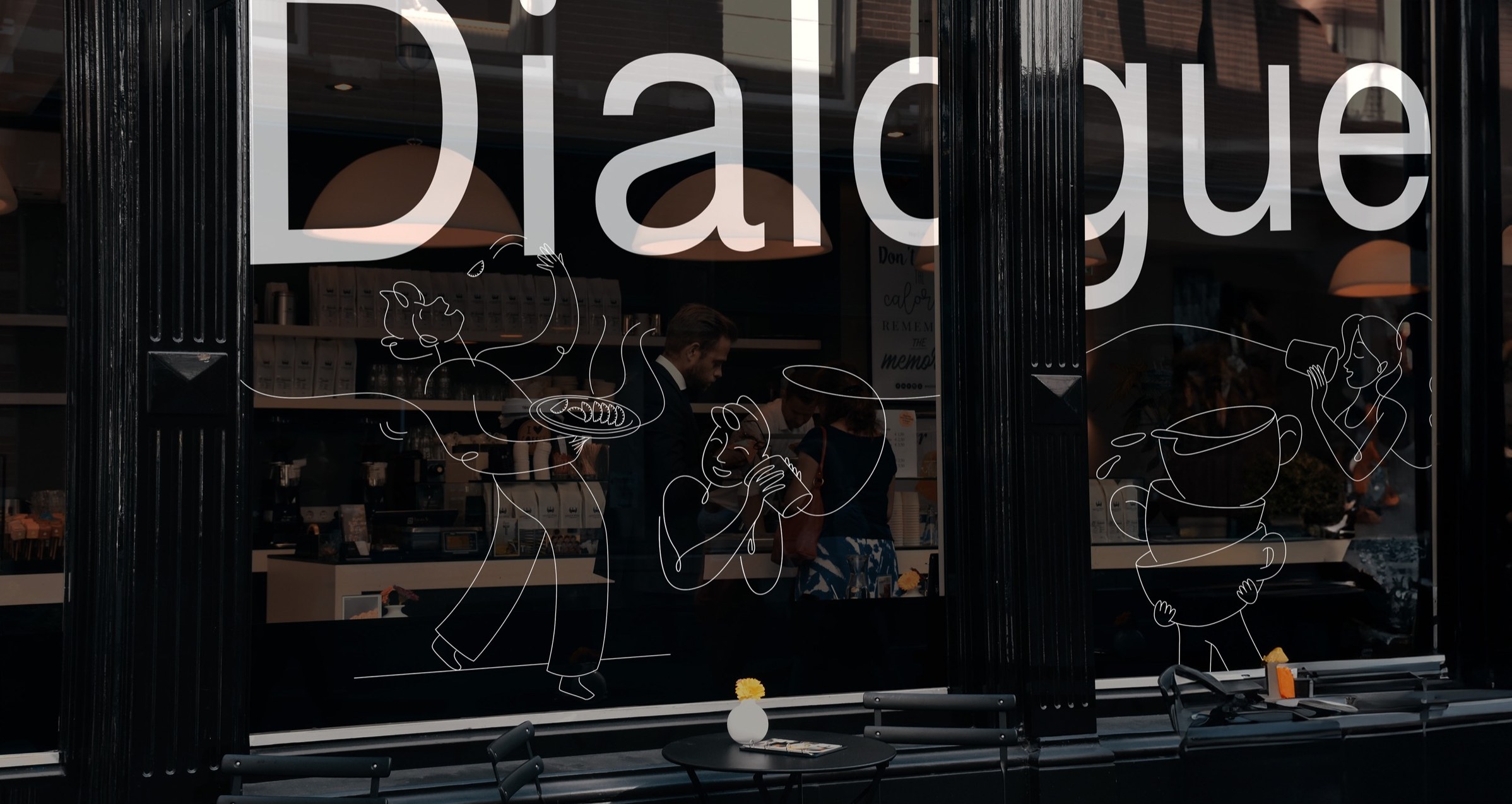 The Dialogue storefront — the wordmark and line illustrations on the café glass